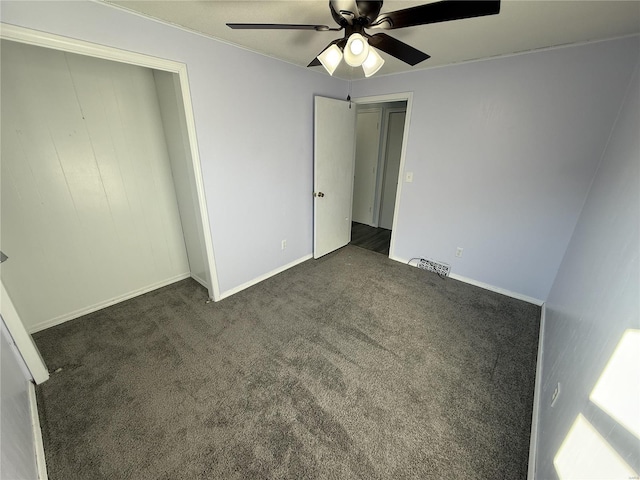 unfurnished bedroom featuring dark colored carpet, baseboards, and a ceiling fan