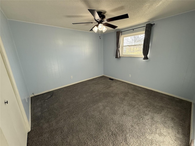 empty room featuring visible vents, a ceiling fan, a textured ceiling, dark carpet, and baseboards