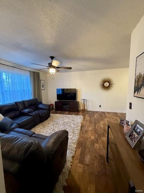 living room with a textured ceiling, a ceiling fan, and wood finished floors