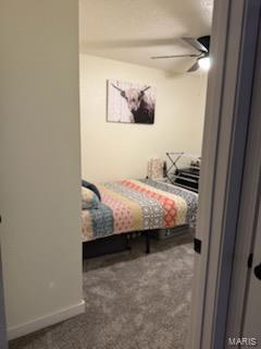 carpeted bedroom featuring baseboards and ceiling fan