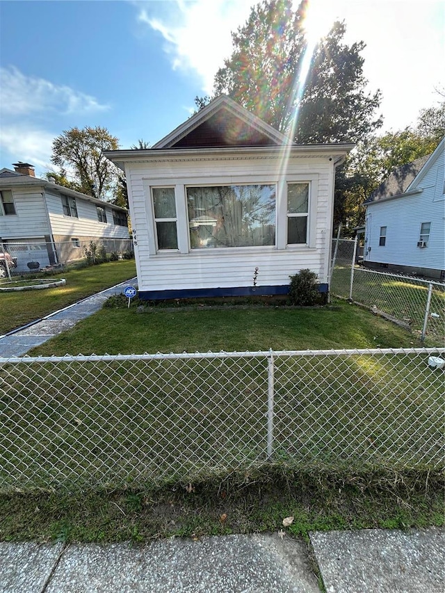 view of side of property with a lawn and fence