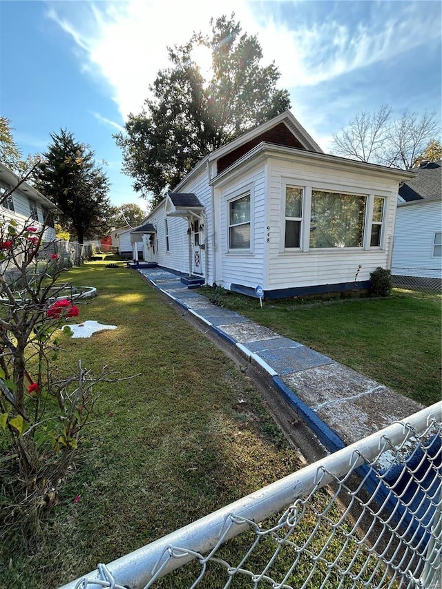 view of property exterior with a lawn and fence