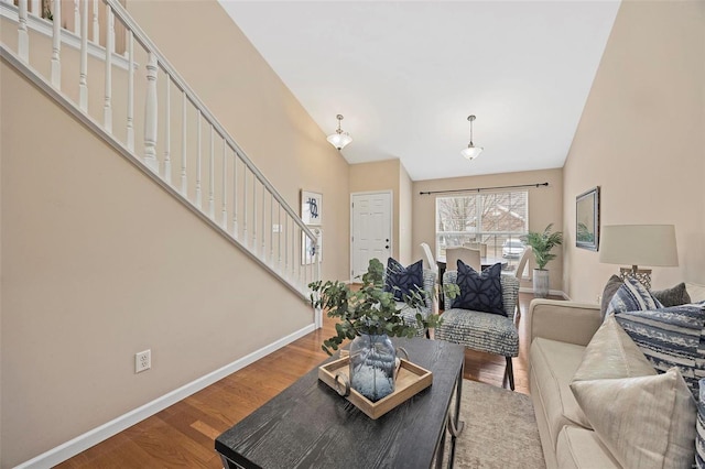 living room with stairway, high vaulted ceiling, baseboards, and wood finished floors