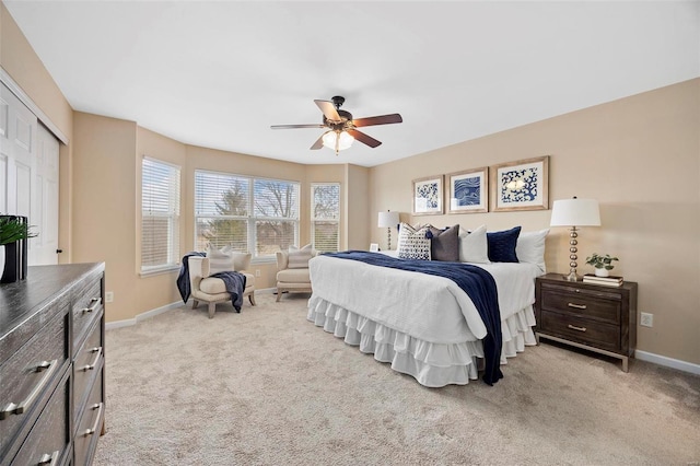 bedroom with a ceiling fan, baseboards, a closet, and light carpet