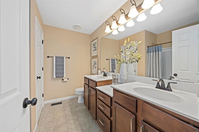 bathroom featuring tile patterned flooring, visible vents, toilet, and a sink