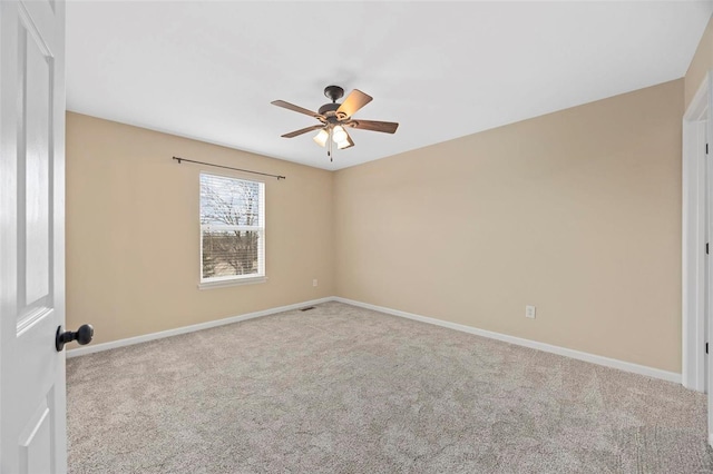 carpeted empty room with baseboards and ceiling fan