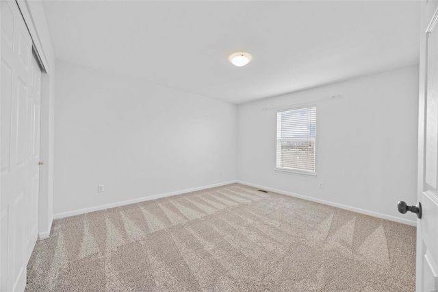 empty room featuring baseboards, carpet floors, and visible vents