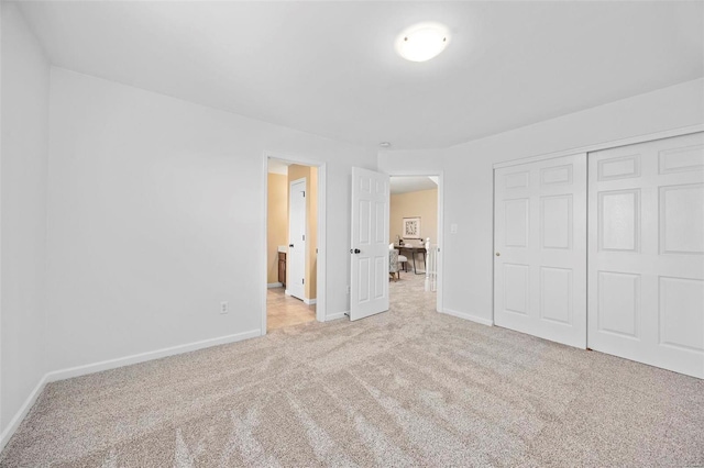 unfurnished bedroom featuring a closet, carpet flooring, and baseboards