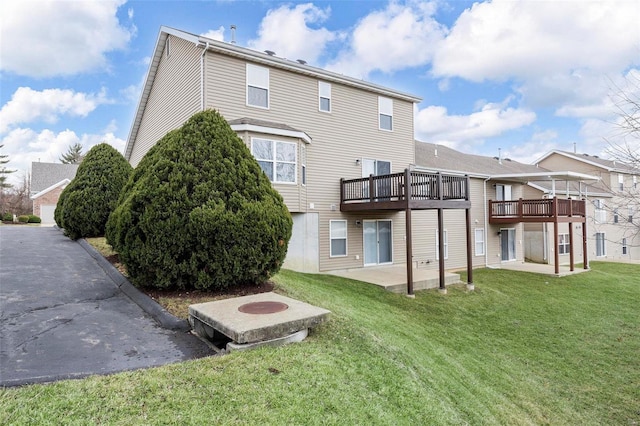 rear view of house featuring a patio area, a deck, and a yard