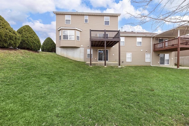 rear view of house featuring a deck and a yard