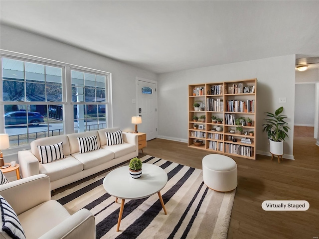 living room with wood finished floors, baseboards, and a healthy amount of sunlight