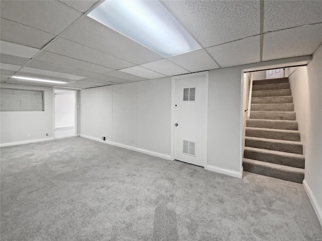 finished below grade area featuring stairway, carpet, and visible vents