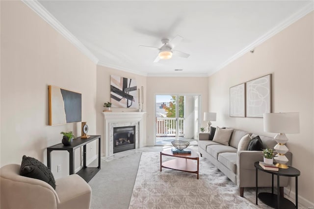 living room with a high end fireplace, baseboards, carpet floors, ornamental molding, and a ceiling fan