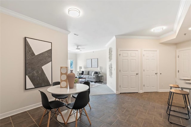 dining room featuring visible vents, a ceiling fan, baseboards, and ornamental molding