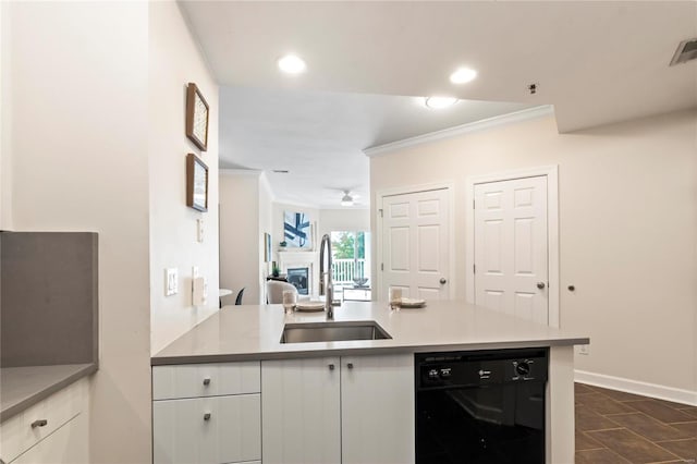 kitchen with dishwasher, ornamental molding, a fireplace, white cabinetry, and a sink