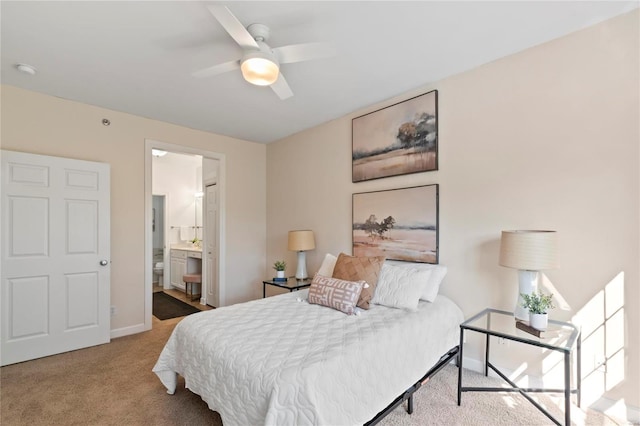 carpeted bedroom with ceiling fan, connected bathroom, and baseboards