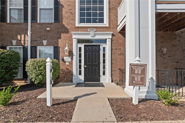 doorway to property featuring brick siding