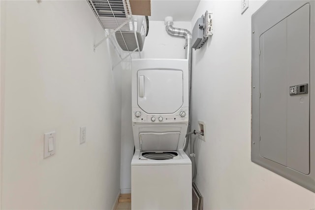 clothes washing area with laundry area, electric panel, and stacked washer and clothes dryer