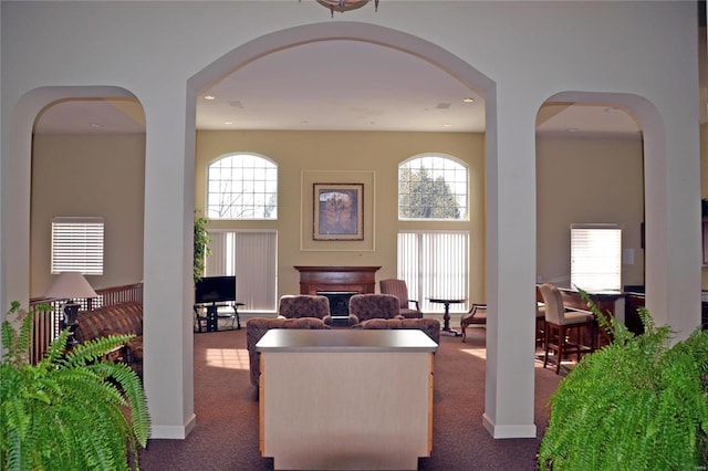 interior space with a high ceiling, recessed lighting, a fireplace, and dark carpet