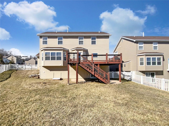 rear view of property with a yard, stairway, a wooden deck, and a fenced backyard