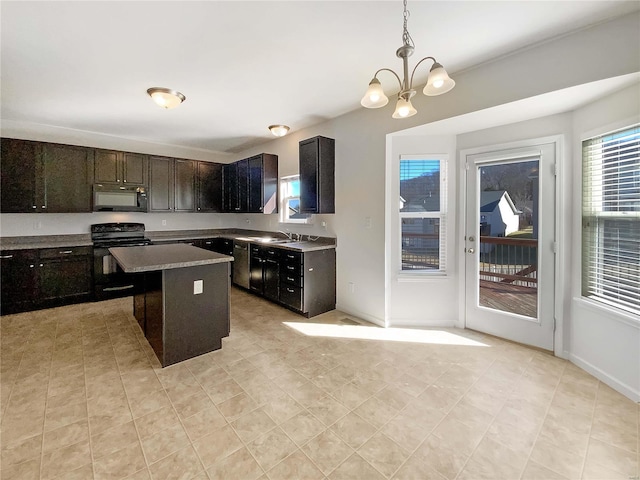 kitchen featuring an inviting chandelier, a sink, hanging light fixtures, black appliances, and a center island