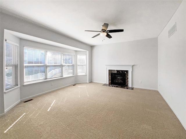 unfurnished living room with baseboards, carpet, visible vents, and a premium fireplace