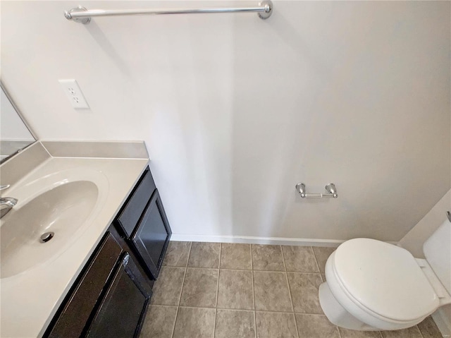 half bath featuring vanity, tile patterned floors, toilet, and baseboards