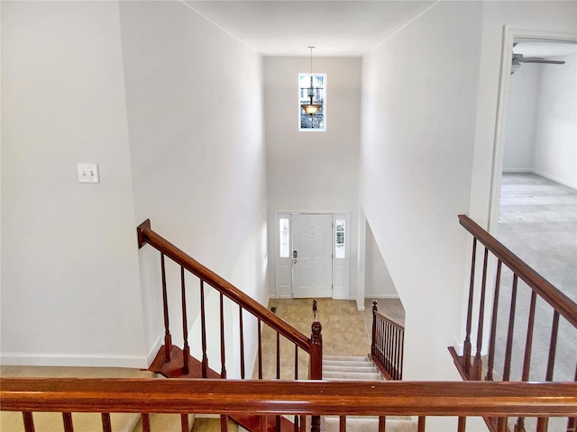 stairs featuring baseboards and a towering ceiling