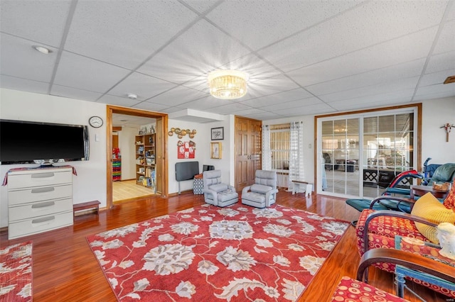 living area featuring a drop ceiling and wood finished floors