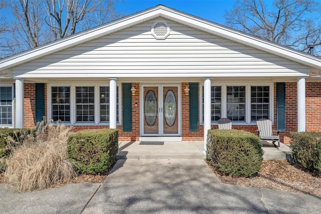 view of front of home with a porch and brick siding