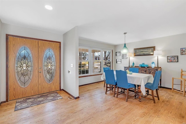 foyer entrance with visible vents, baseboards, and wood finished floors