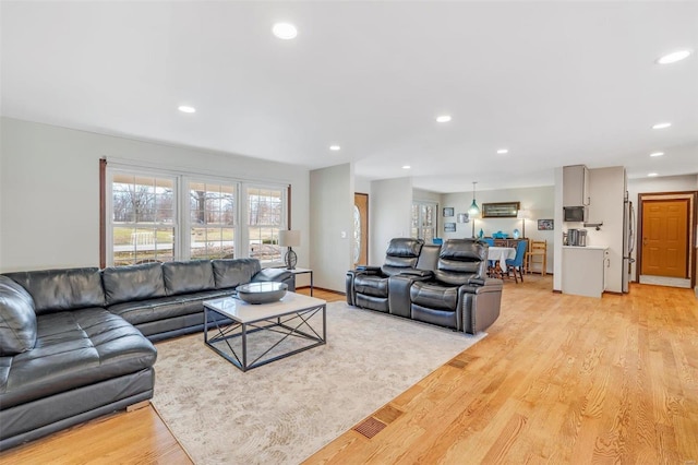 living area with light wood finished floors and recessed lighting