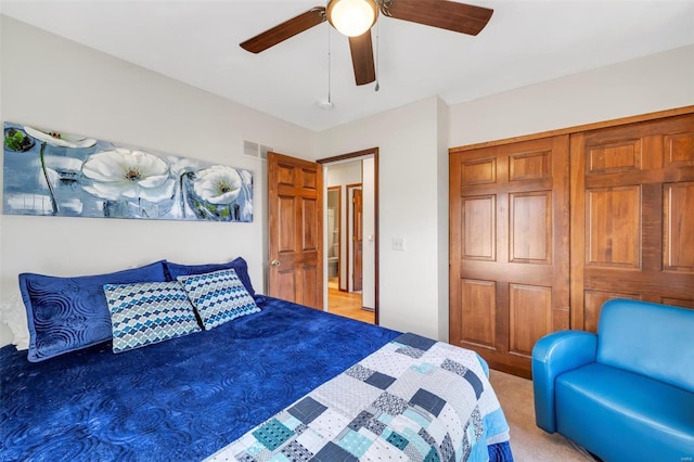 bedroom featuring visible vents, light carpet, a closet, and ceiling fan