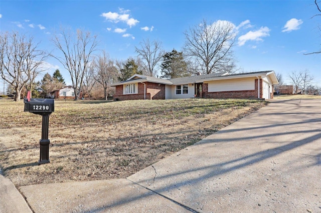 ranch-style home with an attached garage, brick siding, and driveway