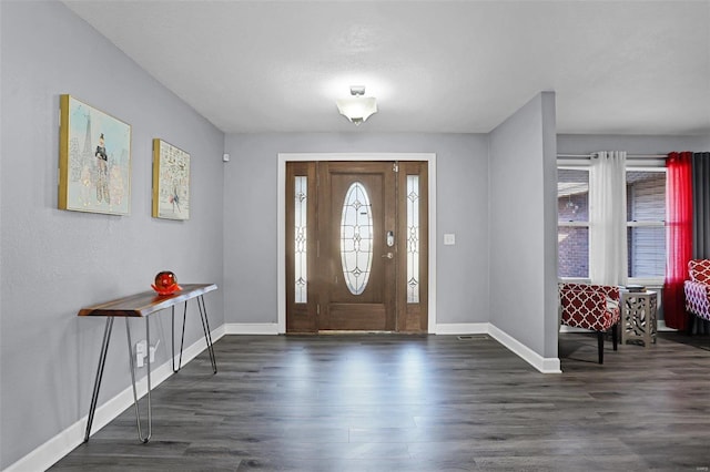 foyer featuring baseboards and dark wood-style flooring