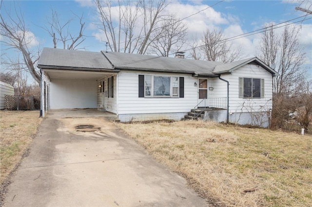 ranch-style home featuring a front lawn, driveway, a shingled roof, a carport, and a chimney