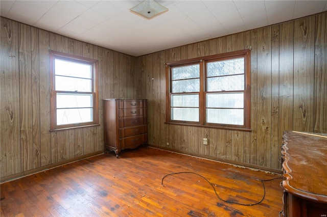 spare room with baseboards and hardwood / wood-style flooring