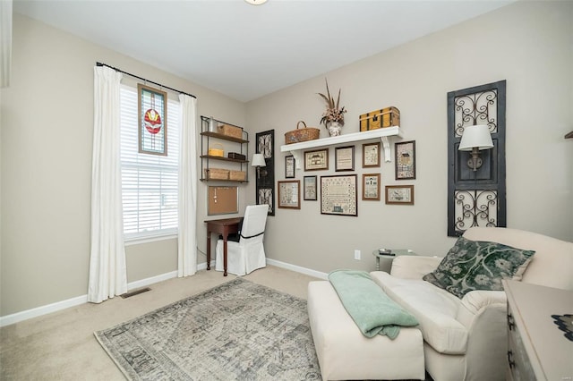 living area featuring visible vents, light colored carpet, and baseboards