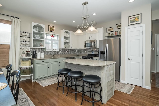 kitchen with dark wood finished floors, open shelves, decorative backsplash, and stainless steel appliances