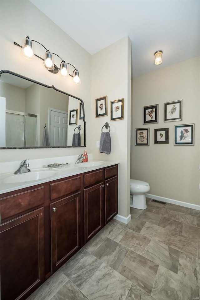 bathroom with a sink, visible vents, a stall shower, and double vanity