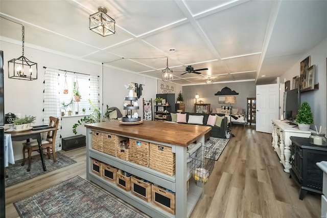 kitchen featuring decorative light fixtures, ceiling fan with notable chandelier, coffered ceiling, and wood finished floors