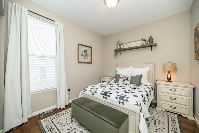 bedroom featuring visible vents, baseboards, and wood finished floors