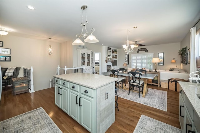 kitchen featuring visible vents, a kitchen island, open floor plan, hanging light fixtures, and dark wood-style flooring