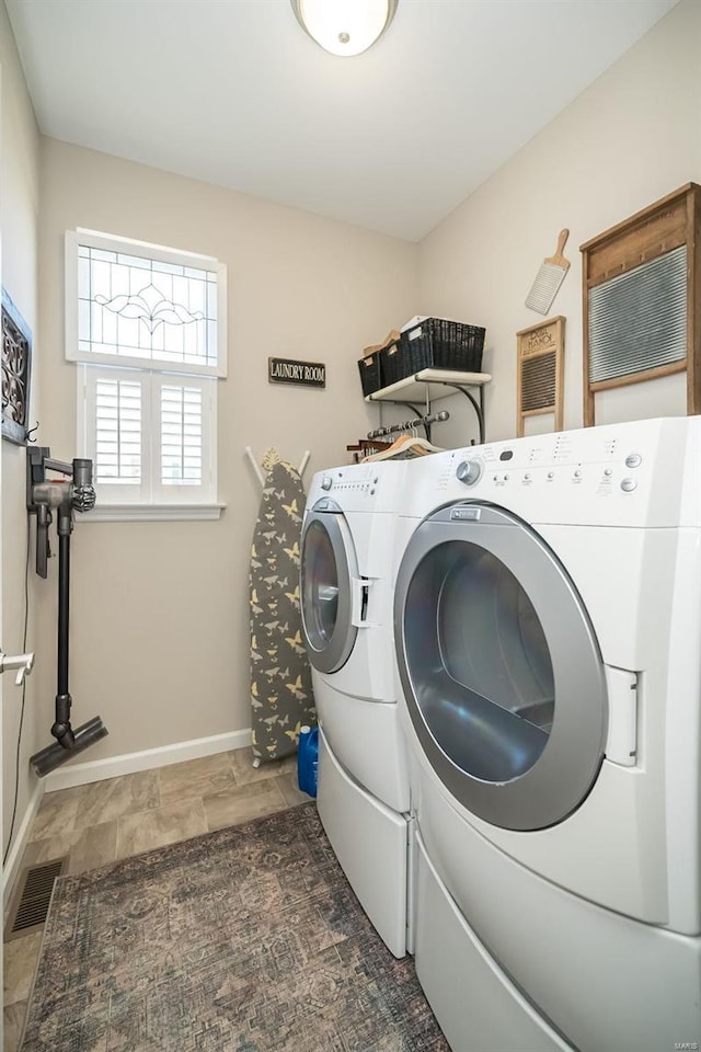 washroom featuring visible vents, baseboards, laundry area, and washer and clothes dryer