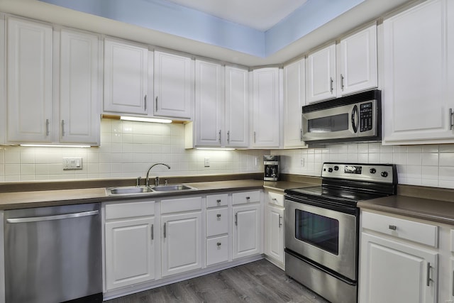 kitchen featuring a sink, dark countertops, white cabinetry, and stainless steel appliances