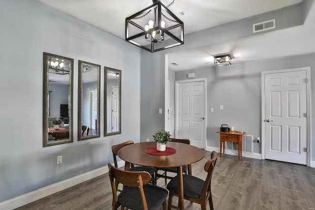 dining area featuring visible vents, baseboards, and wood finished floors