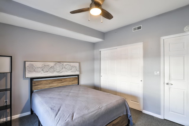 bedroom featuring visible vents, baseboards, dark carpet, a closet, and a ceiling fan