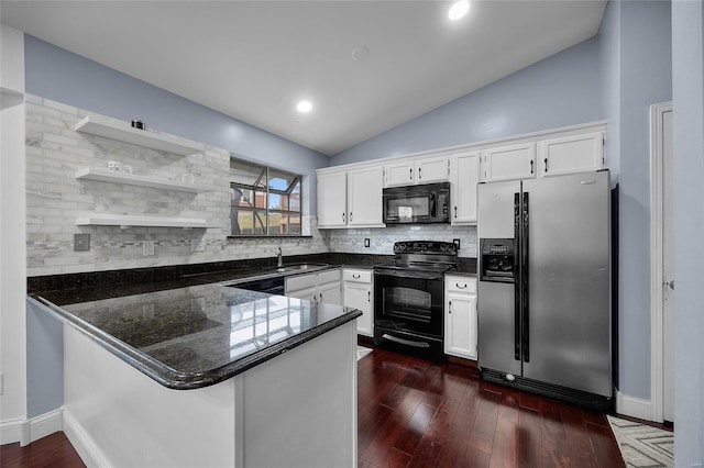 kitchen with black appliances, a peninsula, vaulted ceiling, and white cabinetry