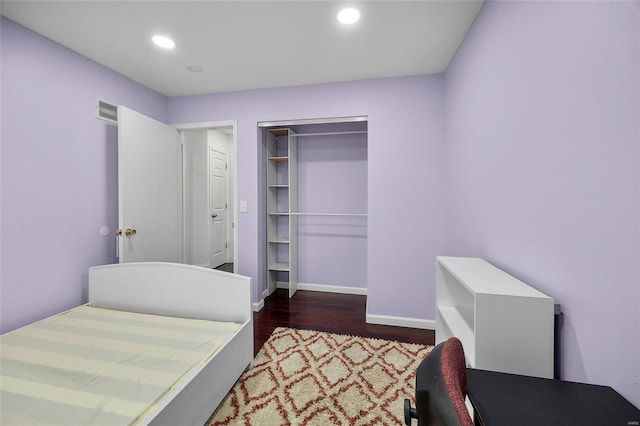 bedroom featuring wood finished floors, visible vents, baseboards, recessed lighting, and a closet