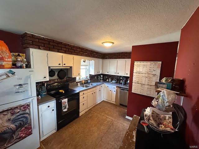 kitchen with brick wall, black appliances, white cabinets, a textured ceiling, and a sink